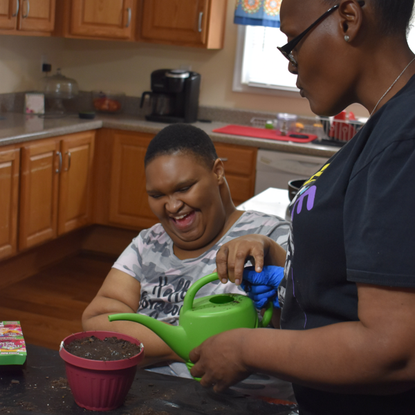 Garber Morris resident planting with staff indoors