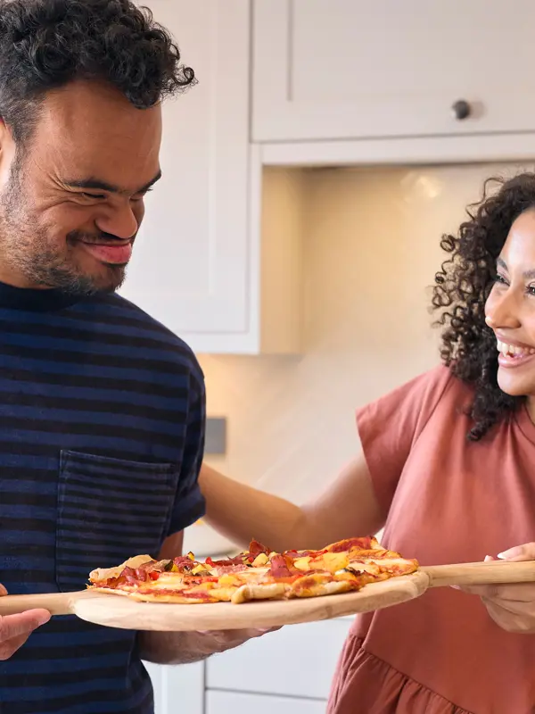 Woman and man cooking pizza