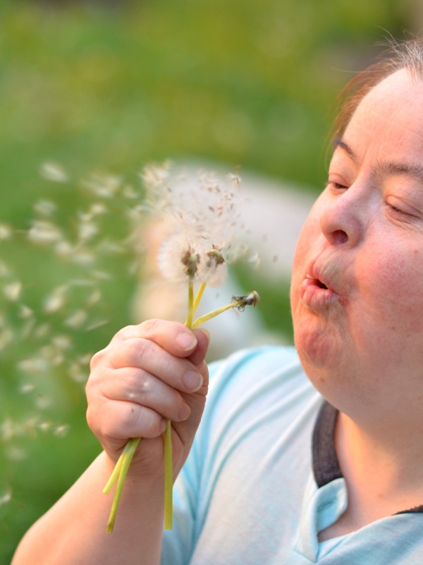 Woman blowing dandelions